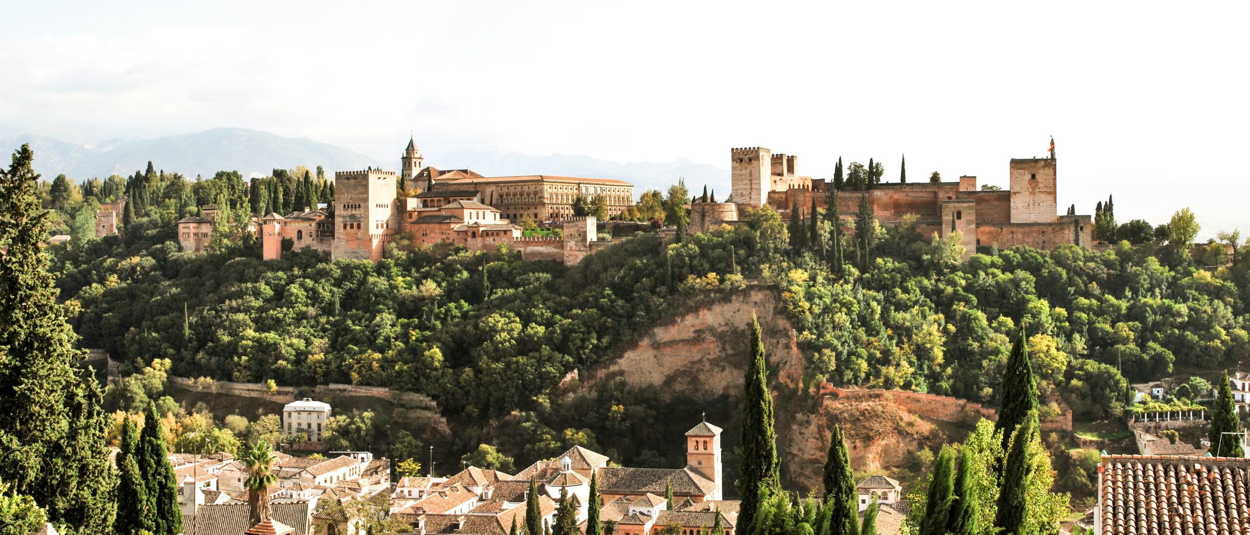 pexels-photo-3049735-3049735 Scenic view of the historic Alhambra Palace in Granada, Spain surrounded by lush greenery.